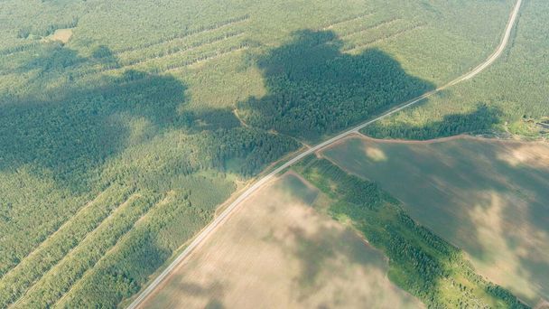 Rusia, Ural. Vuelo sobre el bosque, camino de los campos. Sombras de las nubes, Vista aérea   - Foto, Imagen