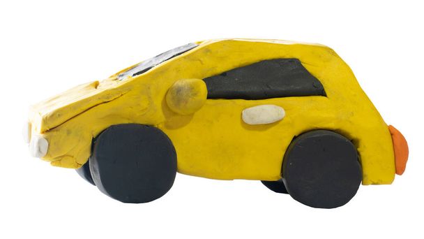 Plasticine in de vorm van een gele auto. Naast uitzicht op een kind-achtige handgemaakte auto. Op geïsoleerde witte achtergrond met clipping pad. - Foto, afbeelding