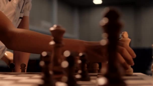 Τα χέρια των παιδιών μετακινούν πιόνια στο σκάκι. Κοντινό πλάνο  - Πλάνα, βίντεο