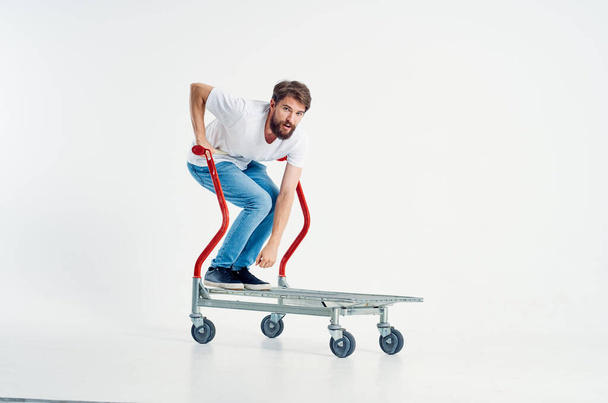 bearded man in a white t-shirt transport in a box light background - Photo, Image