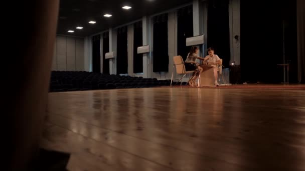 Los niños juegan al ajedrez en una gran sala de conciertos con pisos de madera - Imágenes, Vídeo