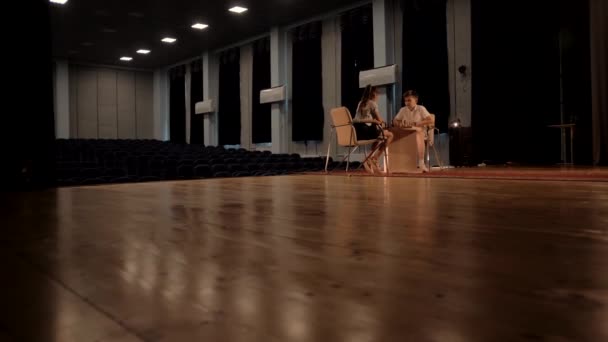 Jeune garçon et fille jouent un jeu d'échecs dans une grande salle de concert - Séquence, vidéo