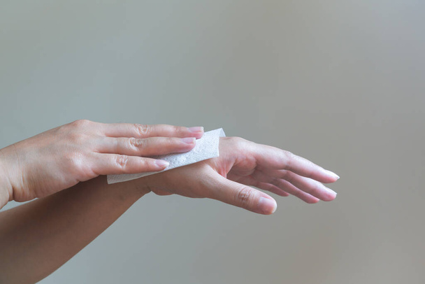 Een vrouw die haar handen schoonmaakt met wit zacht papier. geïsoleerd op een witte achtergrond - Foto, afbeelding