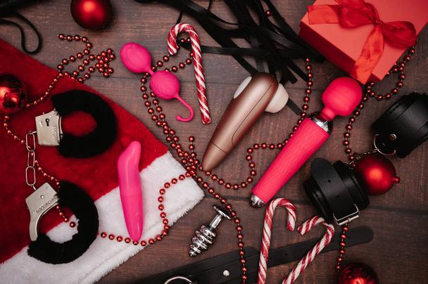 Noel dekorlu bir çift yetişkin BDSM oyuncağı. Düz çizgi. Kelepçe, kamçı, mastürbasyoncular, anal tıkaç, Noel topları.. - Fotoğraf, Görsel