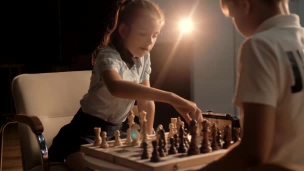 Gyönyörű aranyos iskolás lány sakkozik egy osztálytársával a bajnokság alatt. Mozgókép - Felvétel, videó