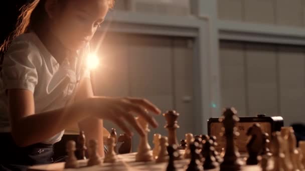Beautiful cute schoolgirl playing chess with a classmate during the championship. Cinematic - Footage, Video