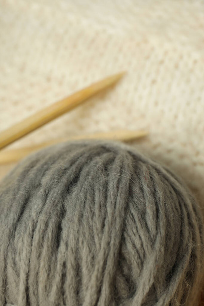 Gray ball of yarn on a light knitted background. - Valokuva, kuva
