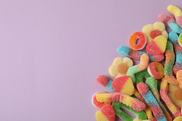 Gummy candies on violet background, space for text. - Foto, Bild