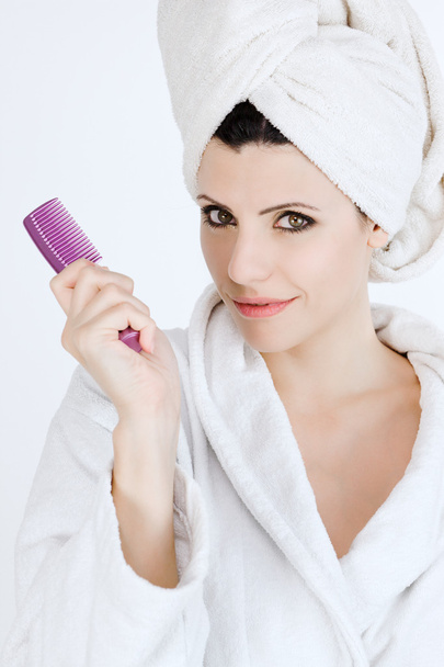 Beautiful woman in bathrobe holding comb - Photo, Image