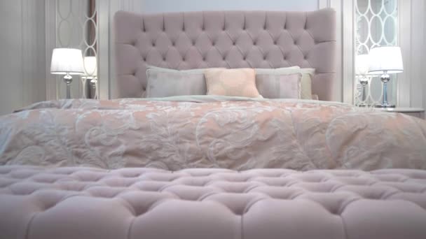 Πολυτελές εσωτερικό ενός υπνοδωματίου με ένα ακριβό κρεβάτι σε μια πολυτελή σουίτα ξενοδοχείου - Πλάνα, βίντεο