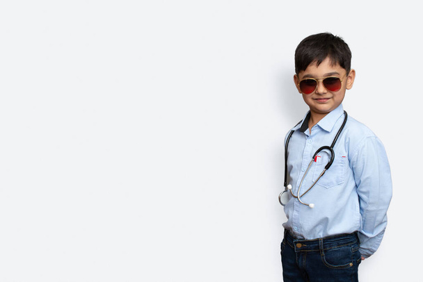 Hymyilevä pieni poika stetoskooppi ja lasit eristetty tausta kopioi tilaa - Valokuva, kuva