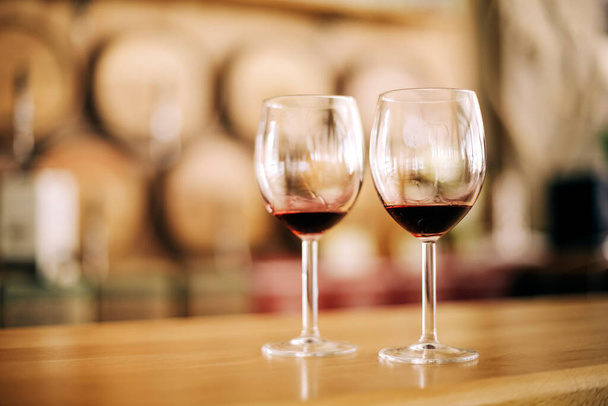 Two glasses of red wine on wooden table in winery - Photo, Image