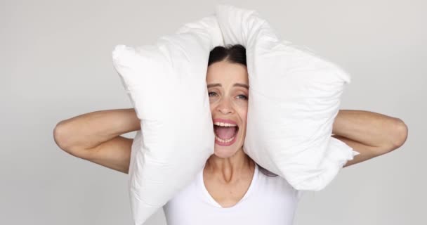 Mujer joven cubriendo sus oídos con almohada y gritando película 4k - Imágenes, Vídeo