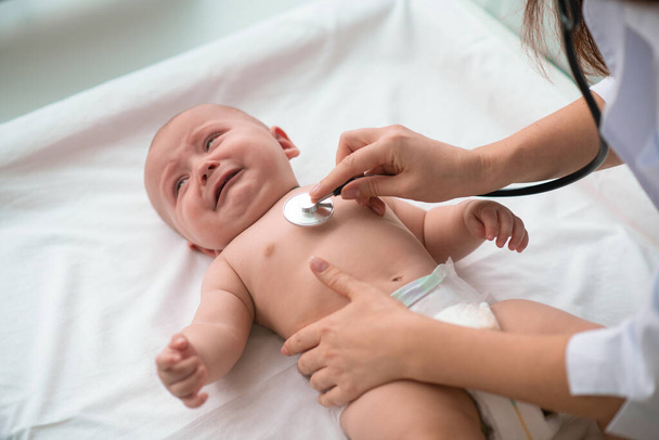 Χαριτωμένο μωρό υποβάλλονται στη διαδικασία auscultation καρδιά - Φωτογραφία, εικόνα