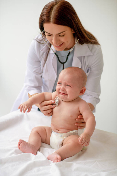 Il giovane pediatra si è concentrato sull'auscultare un neonato - Foto, immagini