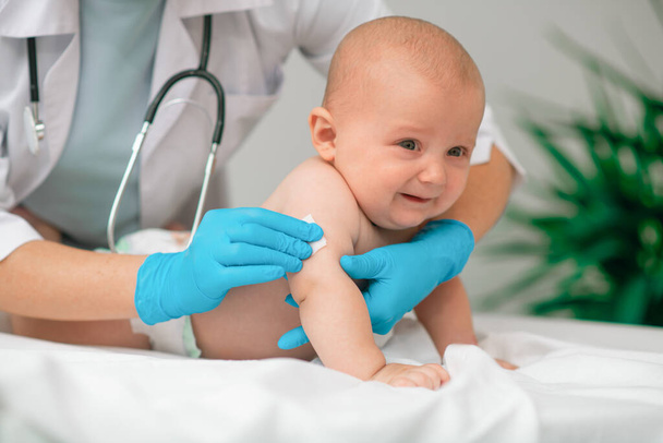 Scared baby being prepared for an upper arm injection - Foto, Imagem