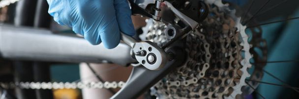 Technikus védőkesztyűben javítás hátsó kerék kerékpár közelkép - Fotó, kép