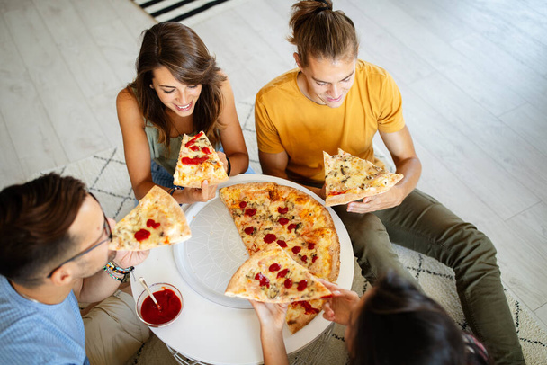 Group of happy friends having party at home, eating pizza and having fun. - Foto, Imagem