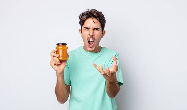 young hispanic man looking angry, annoyed and frustrated. peach jelly concept - Foto, Imagen