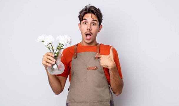 young hispanic man feeling happy and pointing to self with an excited. florist concept - Valokuva, kuva