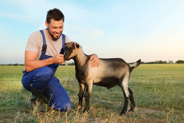 Hombre con cabra en la granja. Cría de animales - Foto, imagen