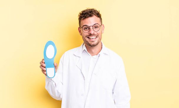 young handsome man looking happy and pleasantly surprised. chiropodist concept - Photo, Image