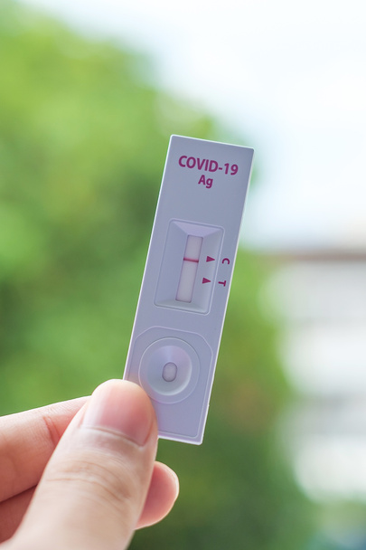 man holding Rapid Antigen Test kit with Negative result during swab COVID-19 testing. Coronavirus Self nasal or Home test, Lockdown and Home Isolation concept - Photo, Image