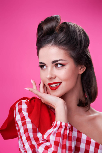 Portrait of a young beautiful girl in retro style looking away. Pink background - Photo, image