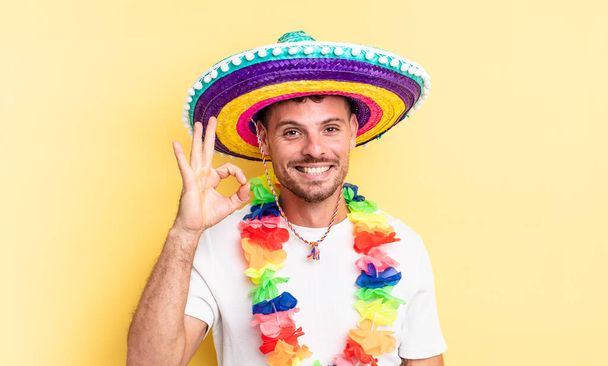 young handsome man feeling happy, showing approval with okay gesture. mexican party concept - Fotoğraf, Görsel