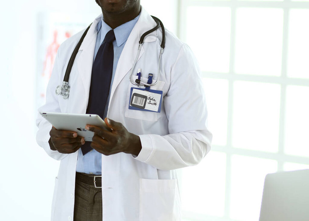 Male black doctor worker with tablet computer standing in hospital - Fotó, kép