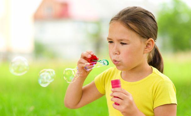 Little girl is blowing a soap bubbles - Foto, Imagem