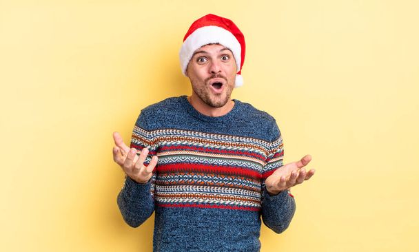 young handsome man feeling extremely shocked and surprised. christmas concept - Valokuva, kuva