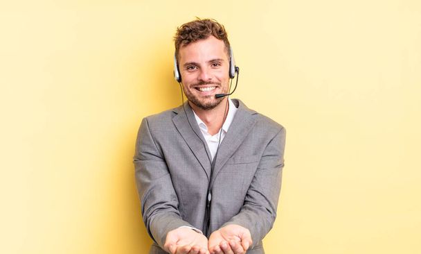young handsome man smiling happily with friendly and  offering and showing a concept. telemarketer concetp - Fotoğraf, Görsel
