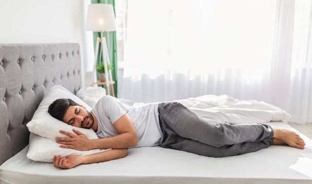 Longitud total del cuerpo del hombre árabe tranquilo durmiendo bien en el lado, descansando, pancarta, espacio libre - Foto, imagen