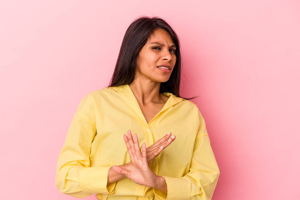 Νεαρή Λατίνα γυναίκα απομονωμένη σε ροζ φόντο κάνει μια χειρονομία άρνησης - Φωτογραφία, εικόνα