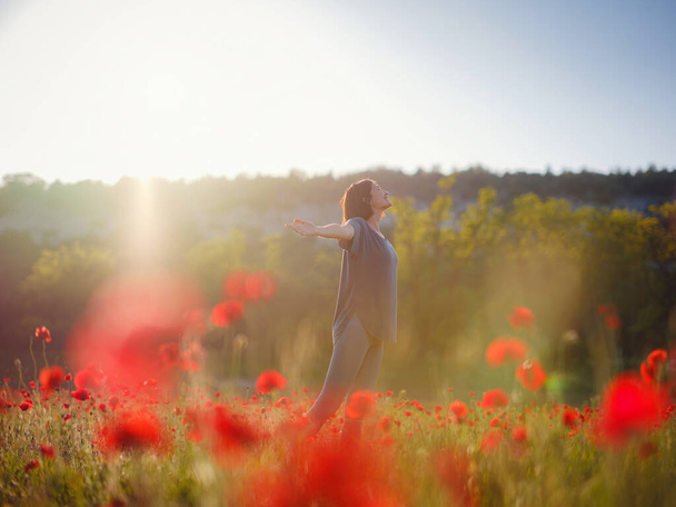 Joven hermosa mujer con los brazos levantados en el campo de primavera - Foto, imagen