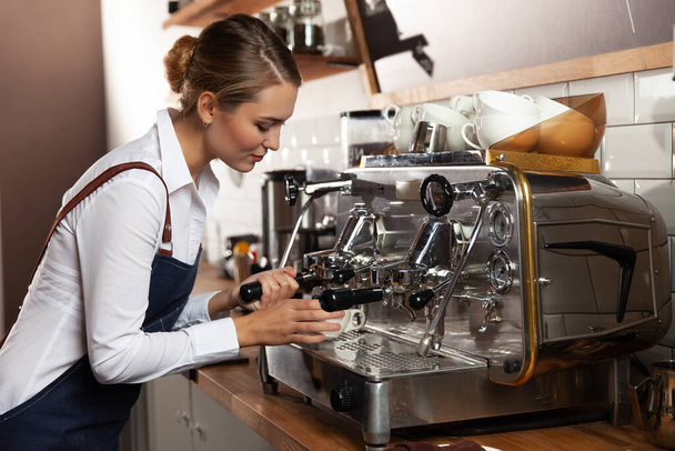 Barista girl makes coffee on a coffee machine. Selective focus. - Fotó, kép