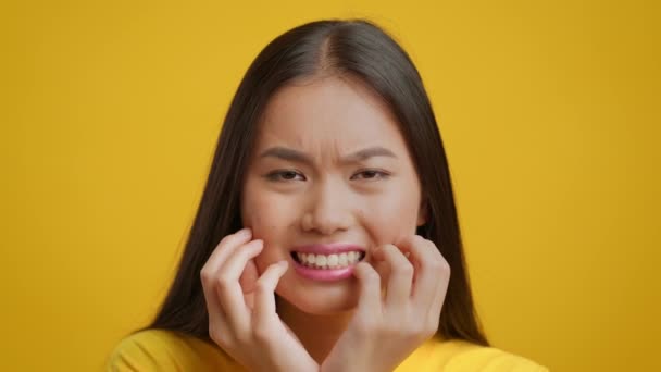 Κινέζα νεαρή κυρία που ανησυχεί για το αίσθημα άγχους Ποζάροντας στο κίτρινο φόντο - Πλάνα, βίντεο