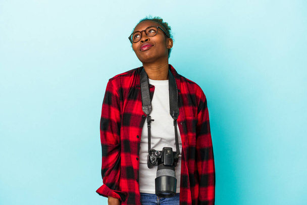 Jeune photographe afro-américaine isolée sur fond bleu rêvant d'atteindre des objectifs et des buts - Photo, image