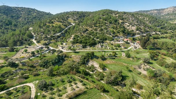 Rural depopulation in Cyprus. Semi-abandoned village of Kato Archimandrita on a hill slope with old ruins and renovated houses, olive and carob trees garden - Photo, Image