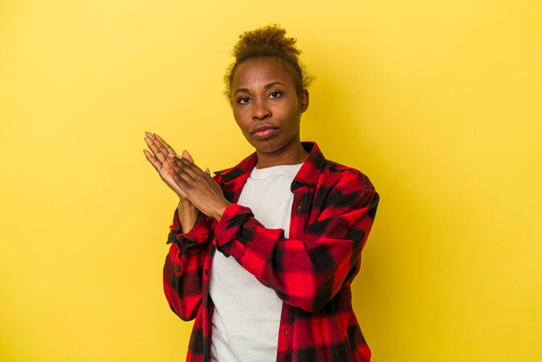 Young african american woman isolated on yellow background feeling energetic and comfortable, rubbing hands confident. - Foto, Imagem