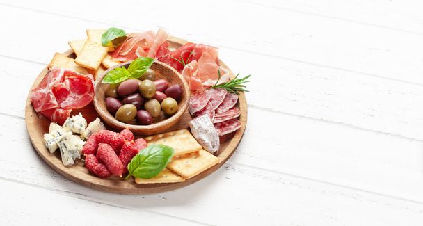 Antipasto board with prosciutto, salami, crackers, cheese and olives. With copy space - Foto, afbeelding