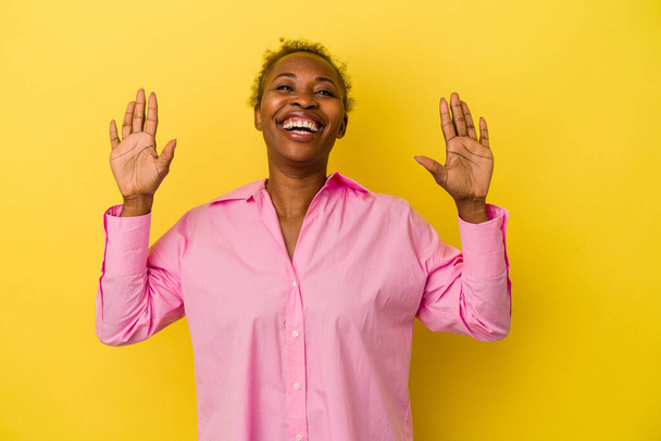 Fiatal afro-amerikai nő elszigetelt sárga háttér mutatja a 10-es számú kezét. - Fotó, kép