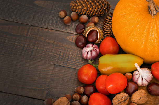 Still Life Imagem conceitual de outono com legumes e nozes. Abóbora, pimentão, castanhas, nozes, tomates, alho. - Foto, Imagem