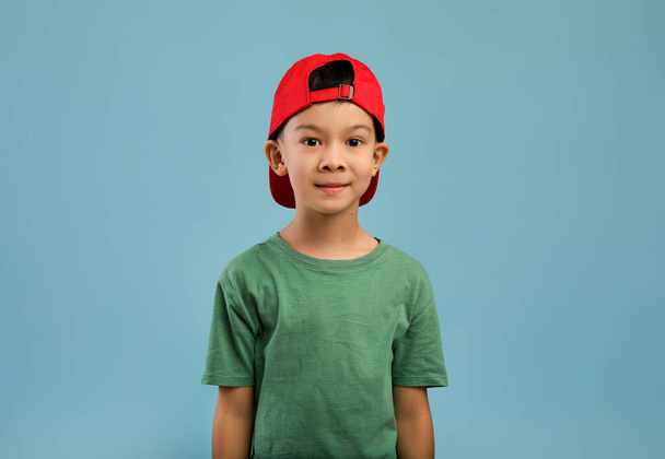 赤い帽子と緑のTシャツのかわいいアジアの男の子の肖像画 - 写真・画像