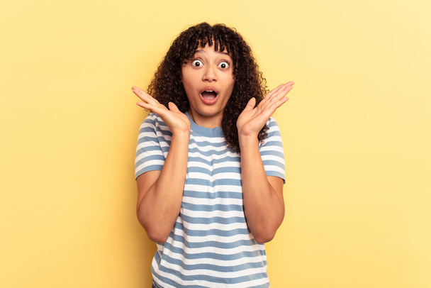 Young mixed race woman isolated on yellow background surprised and shocked. - Foto, Imagen