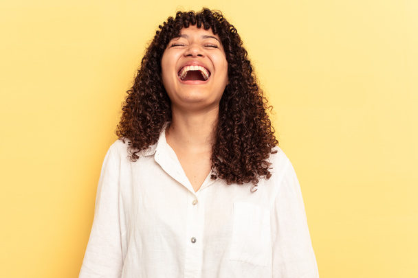 Giovane donna razza mista isolato su sfondo giallo rilassato e felice ridere, collo teso mostrando i denti. - Foto, immagini