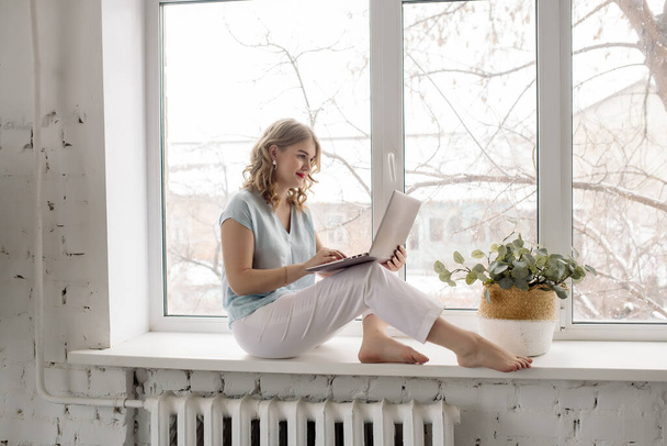 Kaunis nuori nainen freelancer työskentelee kannettavan tietokoneen kotona - Valokuva, kuva