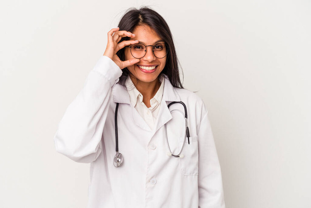 Junge Ärztin lateinisch Frau isoliert auf weißem Hintergrund aufgeregt halten ok Geste auf Auge. - Foto, Bild
