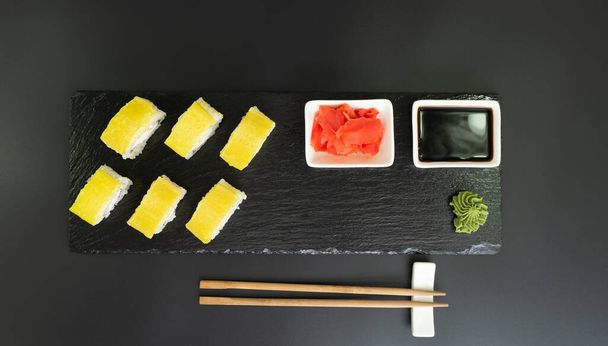 Selección de sushi en pizarra negra, fondo de borde de comida negra - Foto, Imagen